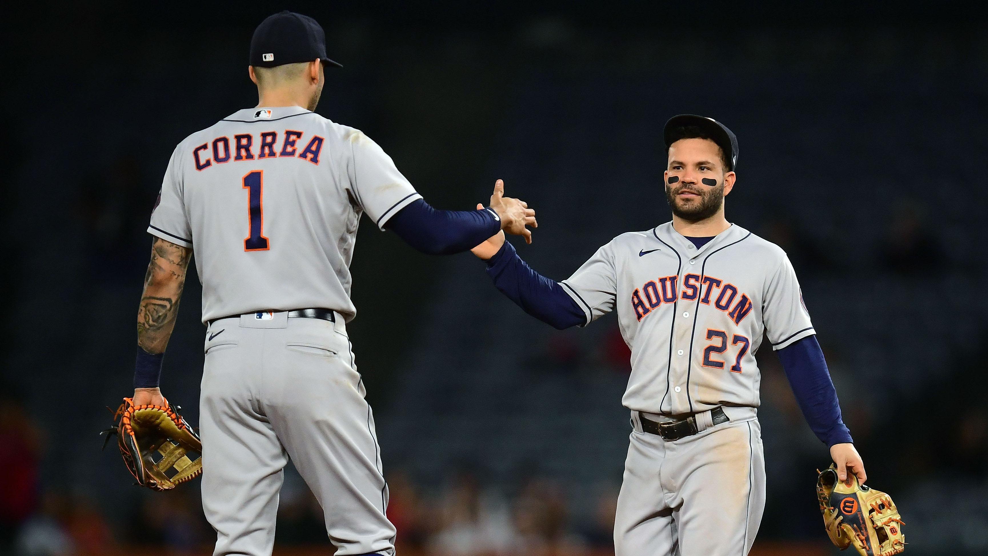 Sep 21, 2021; Anaheim, California, USA; Houston Astros shortstop Carlos Correa (1) and second baseman Jose Altuve (27) celebrate the 10-5 victory against the Los Angeles Angels at Angel Stadium. / Gary A. Vasquez-USA TODAY Sports