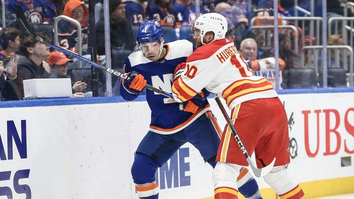 New York Islanders defenseman Samuel Bolduc (4) and Calgary Flames center Jonathan Huberdeau (10) battle for position in this first period at UBS Arena. / Wendell Cruz-USA TODAY Sports