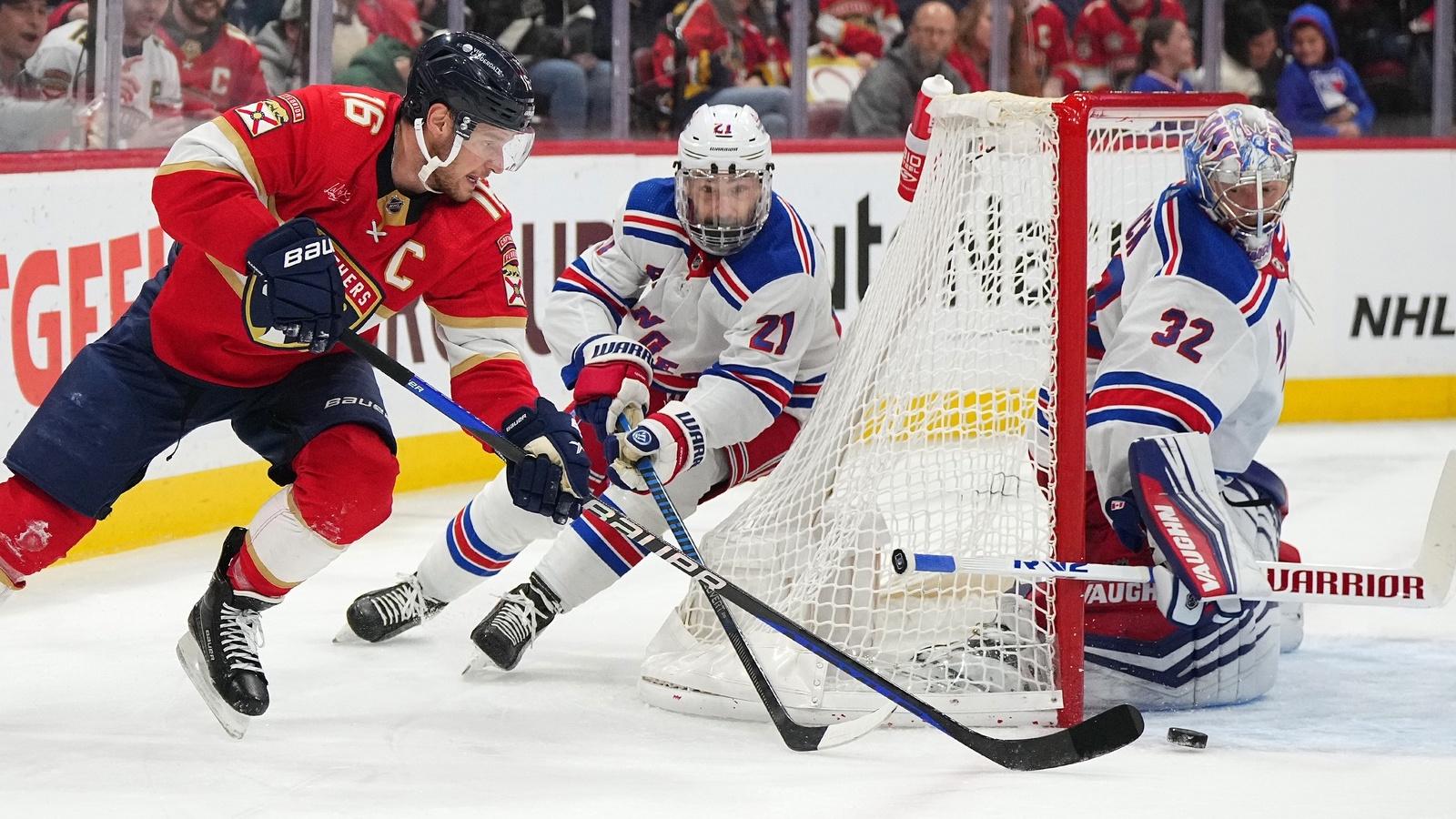 Florida Panthers center Aleksander Barkov (16) passes the puck away from New York Rangers center Barclay Goodrow (21) and goaltender Jonathan Quick (32) during the second period at Amerant Bank Arena. / Jasen Vinlove-USA TODAY Sports
