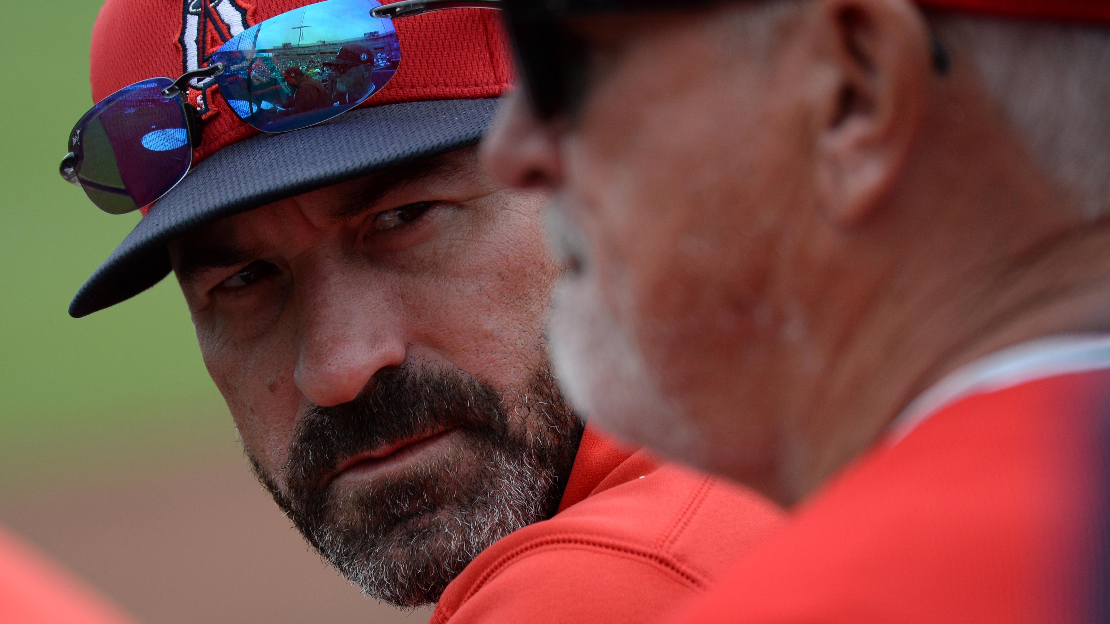Mar 10, 2020; Peoria, Arizona, USA; Los Angeles Angels pitching coach Mickey Callaway (left) talks with manager Joe Maddon during the second inning of a spring training game against the Seattle Mariners at Peoria Stadium. / Joe Camporeale-USA TODAY Sports