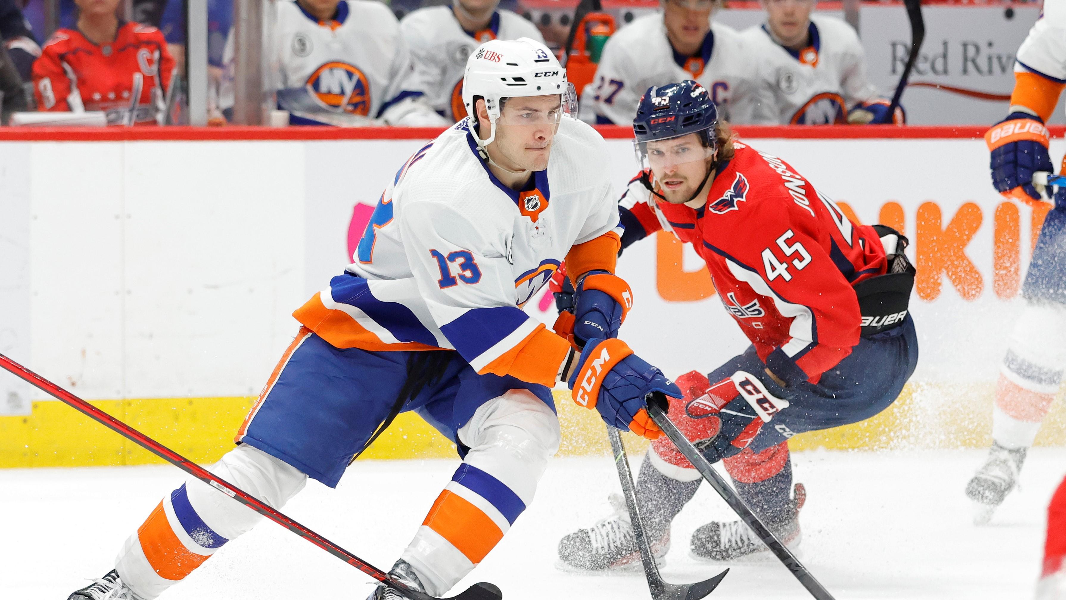 Mar 15, 2022; Washington, District of Columbia, USA; New York Islanders center Mathew Barzal (13) skates with the puck as Washington Capitals left wing Axel Jonsson-Fjallby (45) defends in the second period at Capital One Arena. / Geoff Burke-USA TODAY Sports
